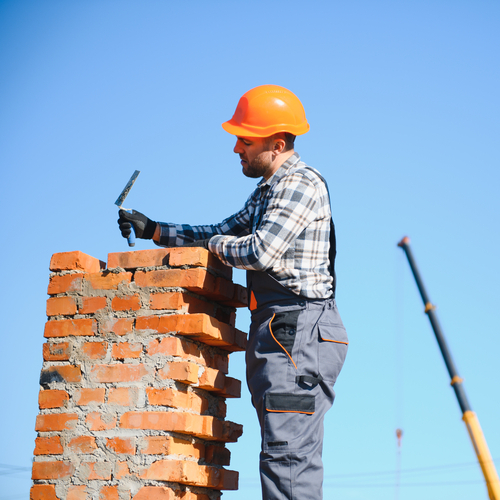 man repairing a brick chimney