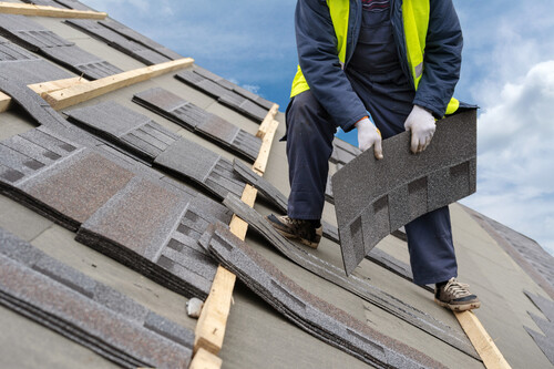 commercial roof and man repairing it