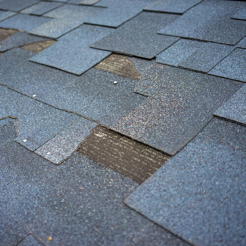 severely damaged shingle roofing