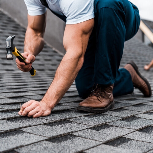 Man installing shingles on a roof